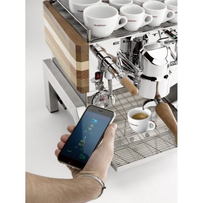 Man holding iPhone infront of an Elektra Verve Home Espresso Coffee Machine