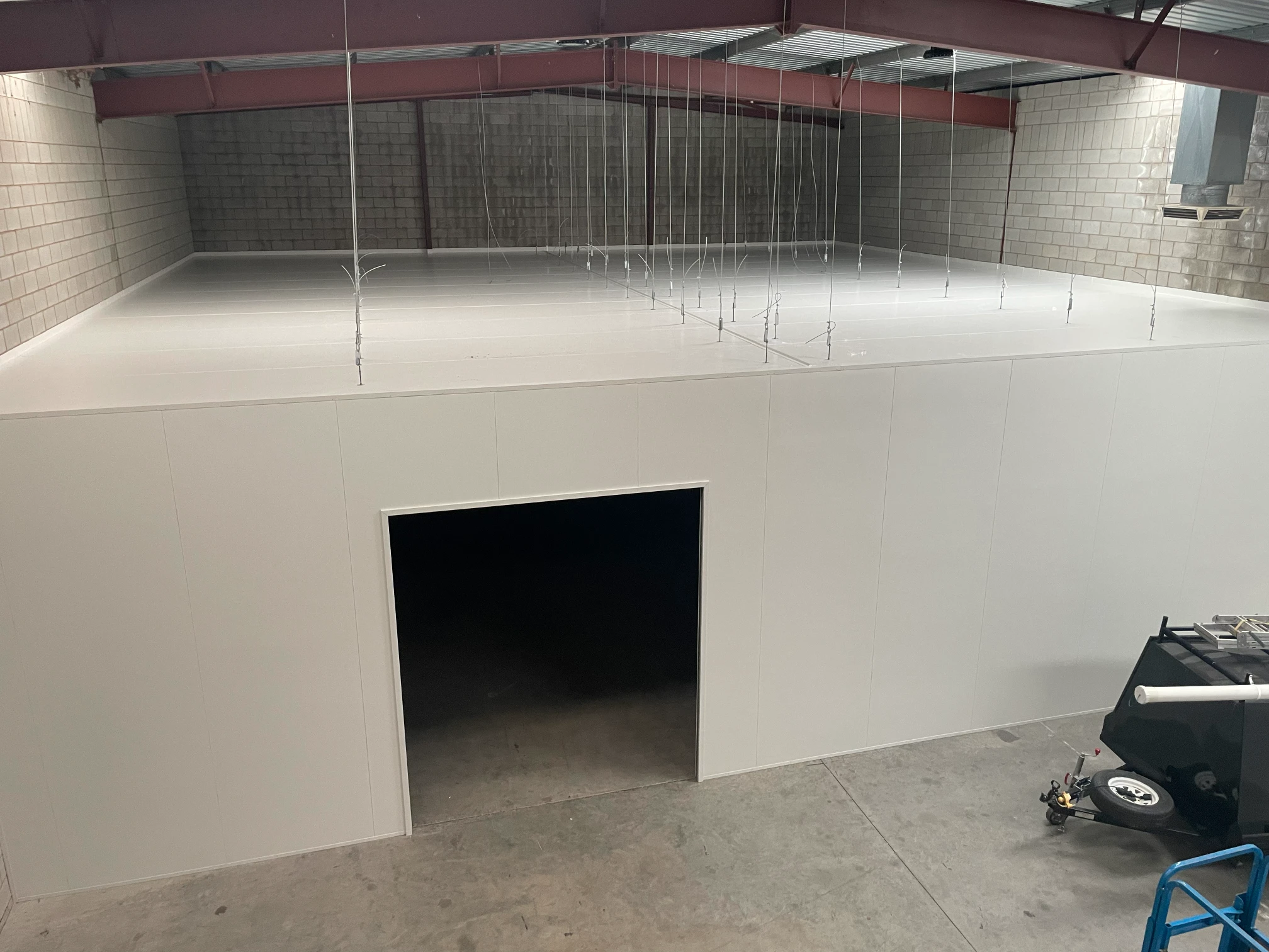 White storage room being constructed within a larger warehouse in Adelaide